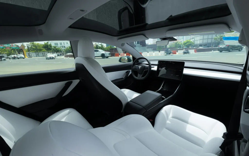 Interior view of Tesla Model S showcasing touchscreen displays and premium materials.